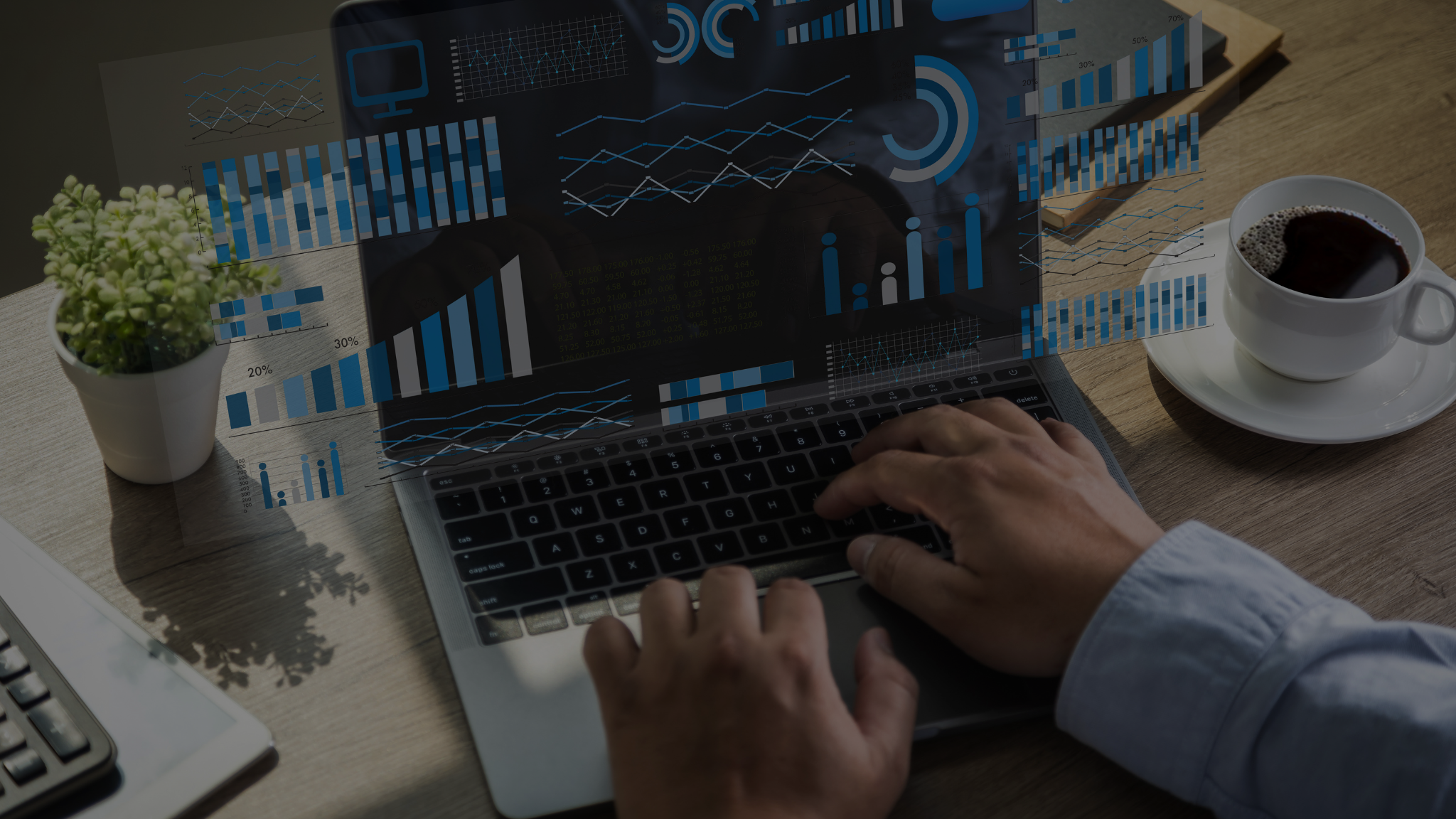 A person typing on a laptop with overlay visuals of business graphs and charts, symbolizing data analysis and strategy. A cup of coffee and a small potted plant are on the wooden desk, emphasizing productivity. Represents Key Business Internationalization Resources and planning.